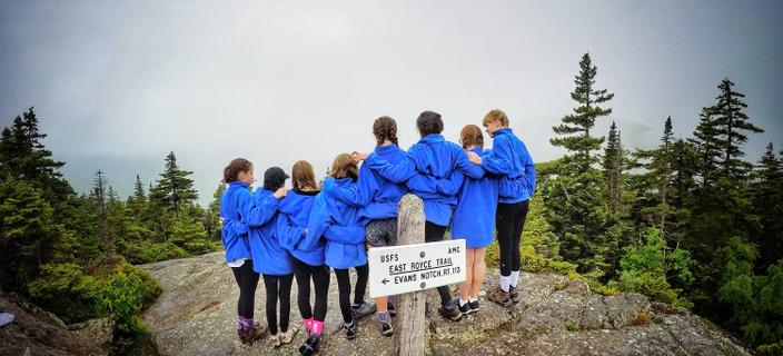 Campers from Camp Tapawingo, Maine, gather at a mountaintop.