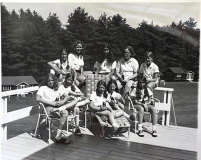 A vintage photo shows girls gathered outside on a summer day at Camp Tapawingo in Maine.