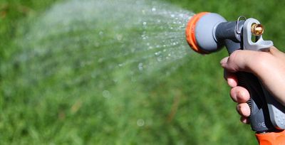 homeowner watering lawn in tulsa