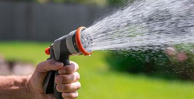 tulsa homeowner watering his lawn