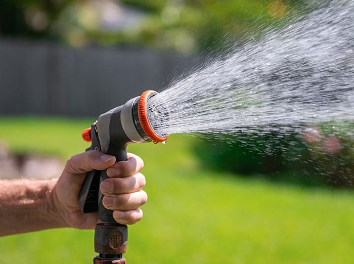 tulsa man watering a lawn